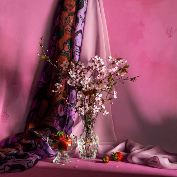 Still life. The vernal flowering branches and strawberries on a table close-up