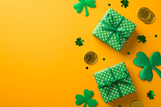 istock Top view photo of st patrick's day decorations two green gift boxes with polka dot pattern shamrocks trefoil shaped confetti and gold coins on isolated yellow background with blank space 1370189770