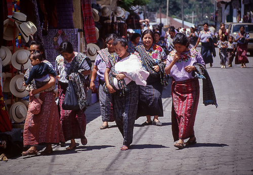Atitlan, Guatemala - aug 17, 1998: a group of women walk on the street between the stalls in the Santa Catarina market on the shores of Lake Atitlan
