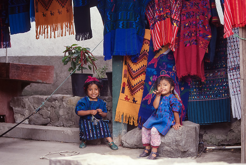 San Antonio Palopo, Atitlan, Guatemala - aug 17, 1998: in San Antonio Palopo, two little girls sitting in front of the small souvenir shop smile and greet passing travelers.