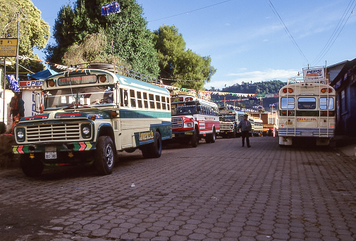 Atitlan, Guatemala - aug 17, 1998: colorful buses parked and waiting for passengers on a street in Santa Catarina on Lake Atitlan