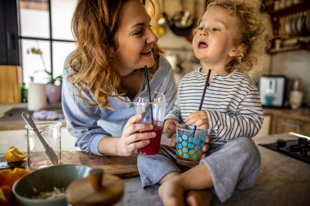 istock Mother and boy drinking fresh home made smoothie in the kitchen 1370195443
