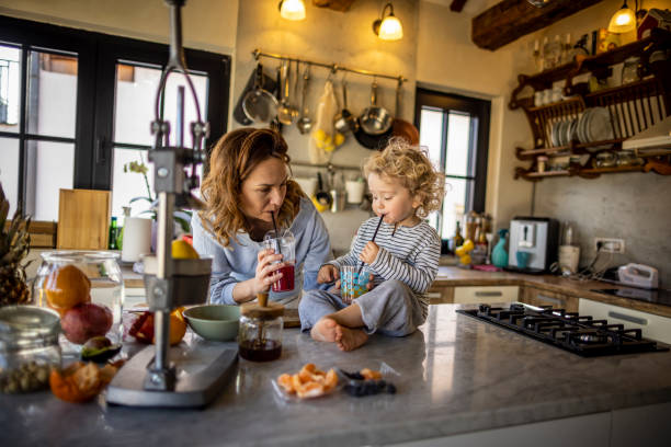 istock Mother and boy drinking fresh home made smoothie in the kitchen 1370196392