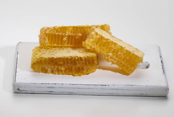 istock wax honeycomb with honey on a white board 1370201780