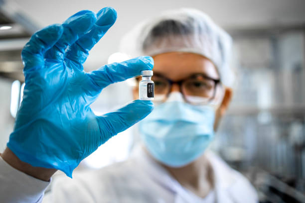 travailleur pharmaceutique ou technologue en équipement de protection contrôlant la qualité de la production de vaccins en usine. - équipement de production pharmaceutique photos et images de collection