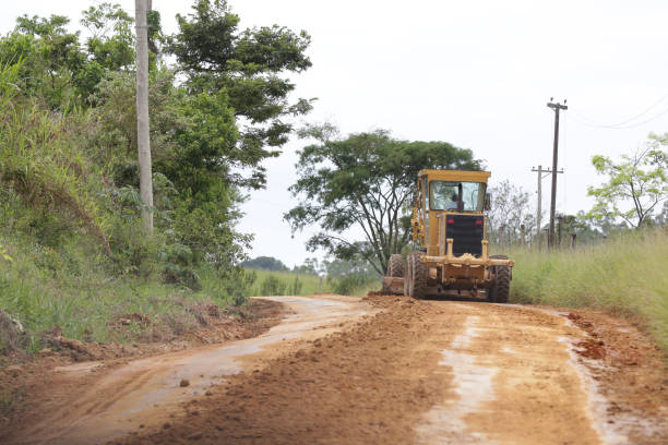istock Tractor working on the rural road removing mud. 1370207589