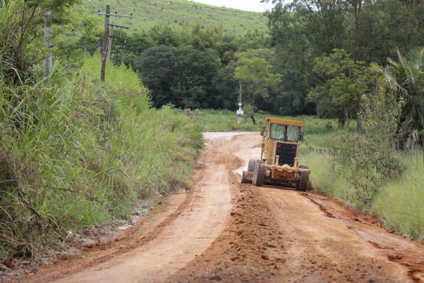 istock Tractor working on the rural road removing mud. 1370207594