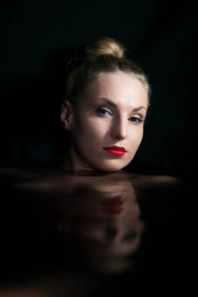istock Beautiful woman taking bath in dark bathroom 1370218597