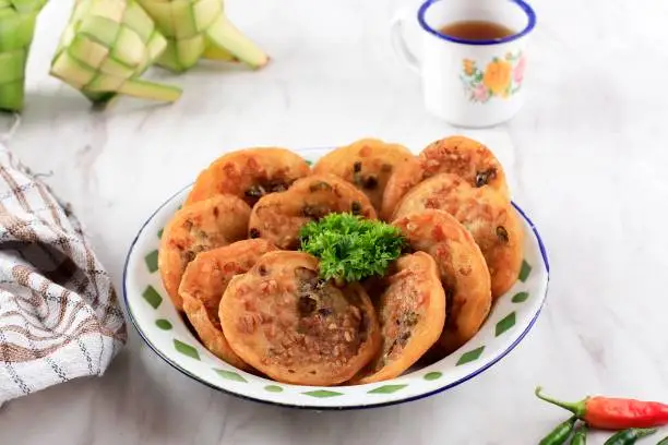 Ote-ote or Bala-Bala is Vegetable Fritter on an Enemel Plate with Green Chilli for Gorengan Takjil Ramadan.