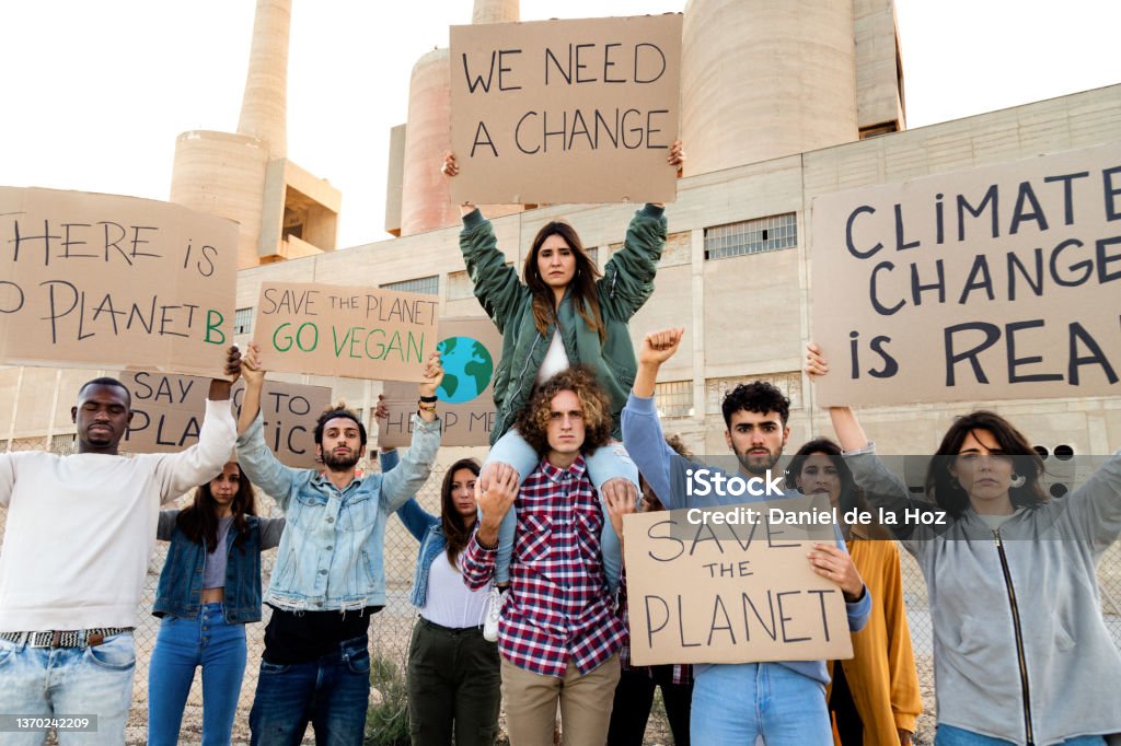 Multiracial people protest against climate change holding signboards in the street. Demonstration to save the planet Multiracial group of people protest against climate change and plastic pollution holding signboards in the street. Demonstration to save the planet. Activist concept. Save The Planet Stock Photo
