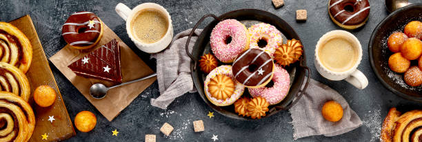 istock Table with various cookies, donuts, cakes and coffe cups 1370242812