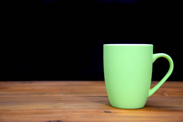 istock A green ceramic mug on wooden background. 1370248498