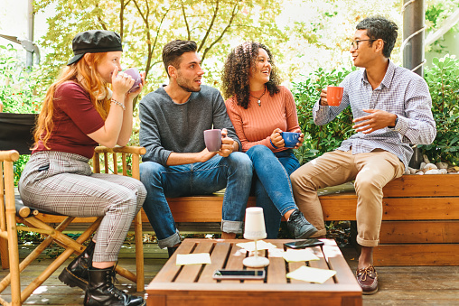 Grupo de jóvenes amigos multiculturales pasando el rato en un patio photo