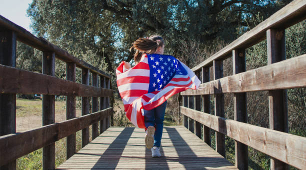 istock Little Girl Holding American Flag While Running. 1370255364