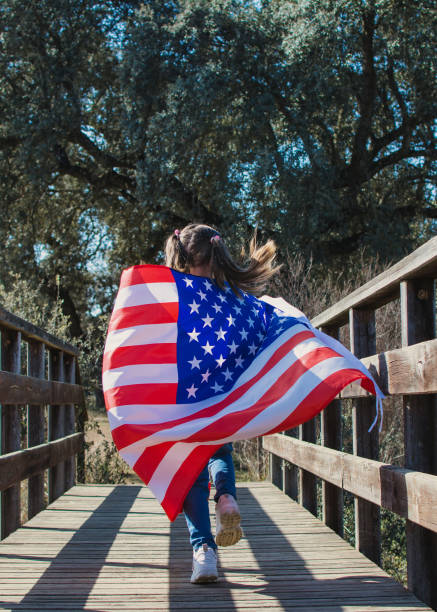 istock Little Girl Holding American Flag While Running. 1370255365