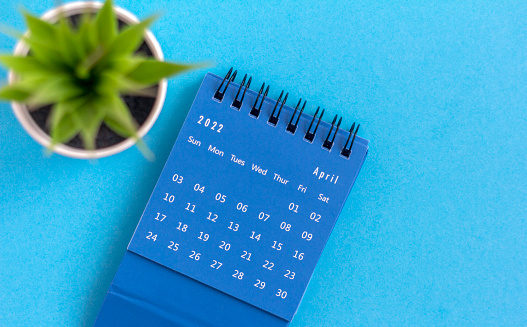 Desktop blue calendar for April 2022 on a blue background
