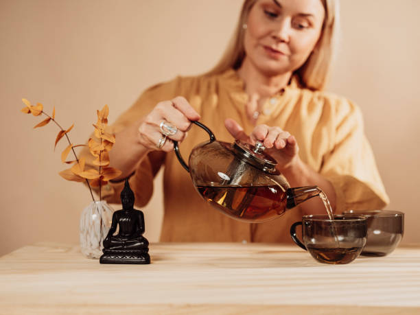 istock Woman making tea with teapot 1370258416