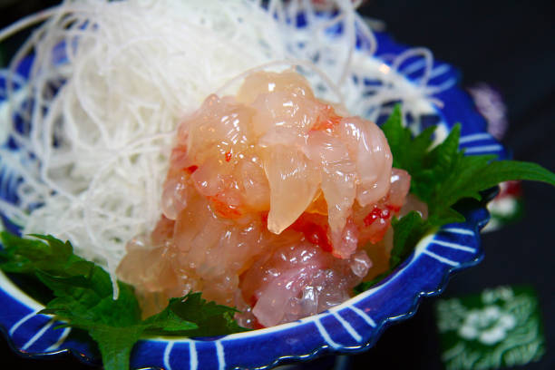Spiny lobster(Iseebi) sashimi, dressed with liver sauce, and decorated with Shiso leaf in a small washoku dish. stock photo