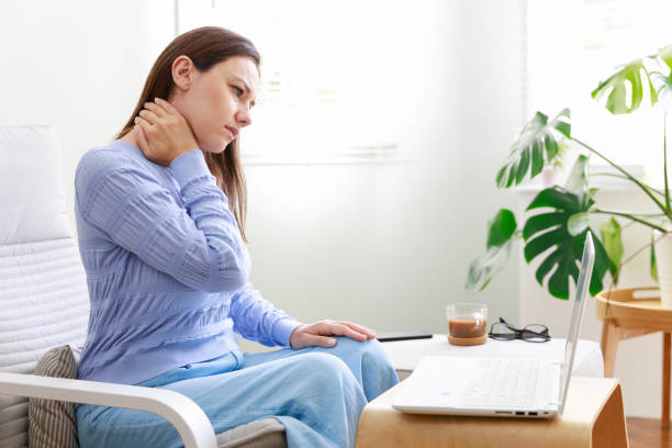 istock Freelance young woman suffering from neck pain while working on computer at home 1370258764