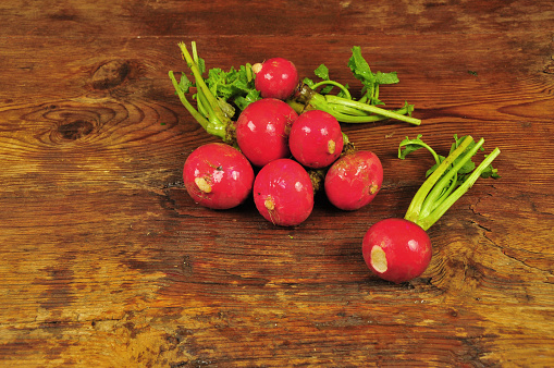 Fresh organic radishes on old wooden table