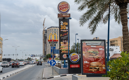 Doha, Qatar - January 16th 2022: Fast food outlets advertising along the c ring road in Doha, Qatar