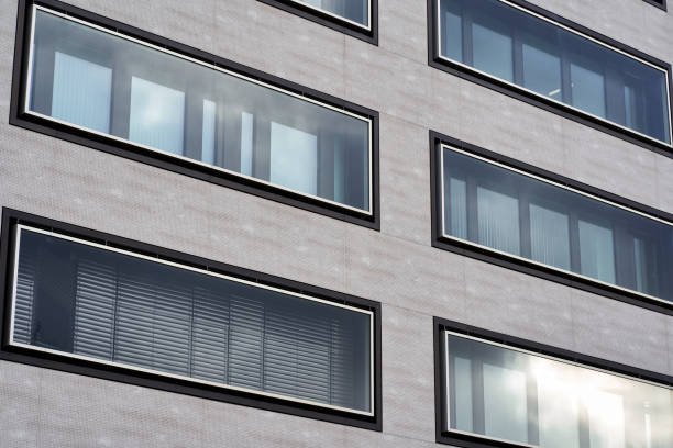 istock Modern building facade of residential and commercial premises. Rectangular large windows in gray house. Up view. 1370265926