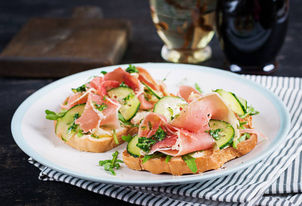 istock Breakfast or brunch.  Open sandwich with prosciutto or jamon on white plate. Mediterranean appetizer. 1370268471