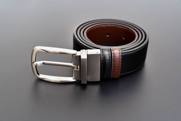 istock Double-sided black and brown leather belt with an unbuttoned buckle on a black. 1370268571