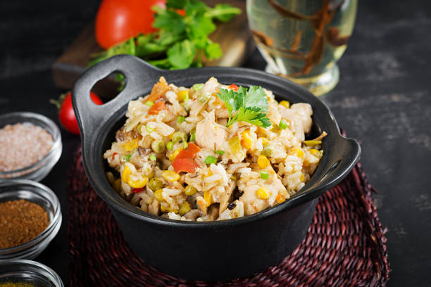istock Rice with chicken and vegetables in bowl on dark background. Diet menu. Lunch. 1370268684