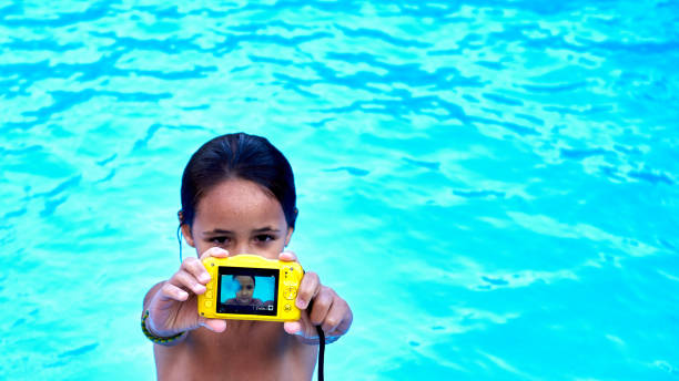 Selfie in the pool with copy space on the right. 6-year-old girl takes a selfie in her pool at home. Copy Space on the right. underwater camera stock pictures, royalty-free photos & images