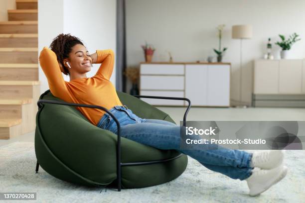 Calm Black Woman Having Rest At Home On Bean Bag Stock Photo - Download Image Now - Relaxation, Sofa, Women
