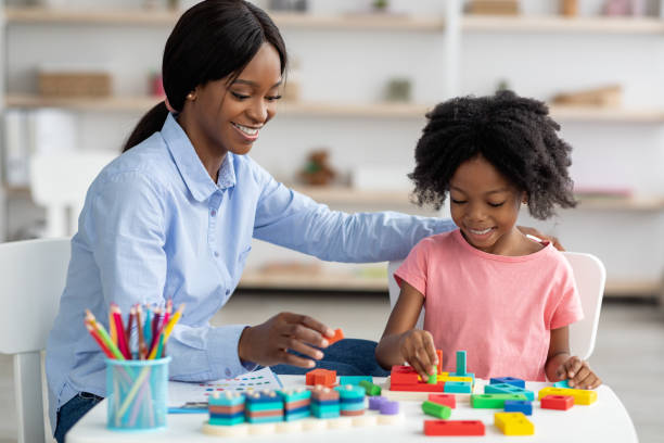 istock Pretty black kid and child development specialist playing with bricks 1370271109