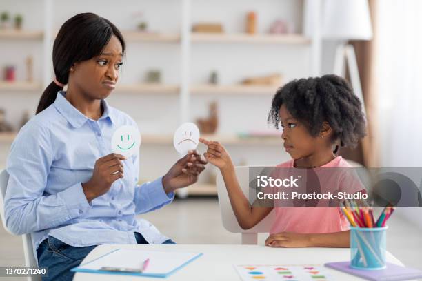 Female Psychologist And Little Black Girl Exercising At Daycare Stock Photo - Download Image Now