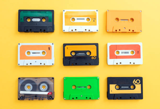 MANY VINTAGE CASSETTE AUDIO TAPES ISOLATED ON YELLOW BACKGROUND. MANY VINTAGE CASSETTE AUDIO TAPES ISOLATED ON YELLOW BACKGROUND. yellow tape audio stock pictures, royalty-free photos & images