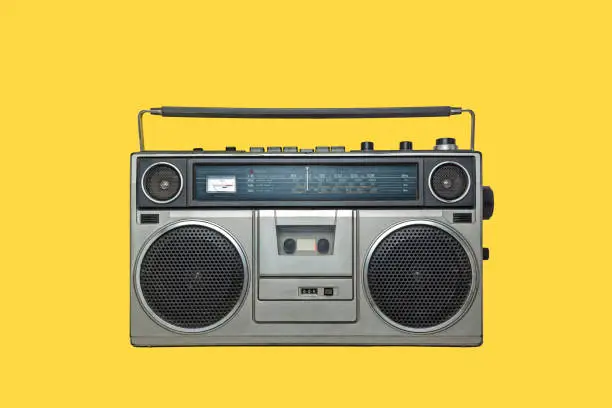 Photo of RADIO CASSETTE PLAYER ISOLATED ON YELLOW BACKGROUND. URBAN MUSIC FASHION FROM THE EIGHTIES.