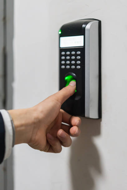 istock Man unlocks door with thumbprint 1370273688