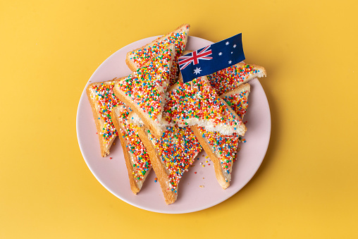 The famous traditional Australian food Fairy Bread on a yellow background.