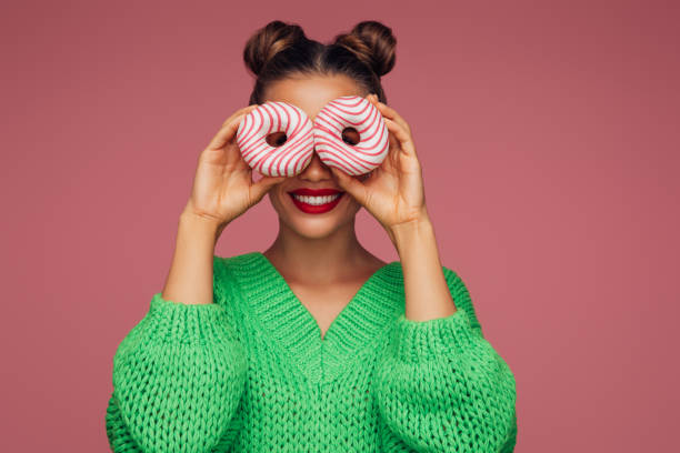 istock Beautiful woman holding donuts 1370279858