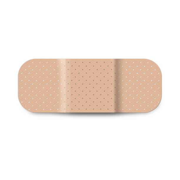 Adhesive bandage Textured beige adhesive plaster on white background. Medical patch aid. adhesive bandage photos stock pictures, royalty-free photos & images