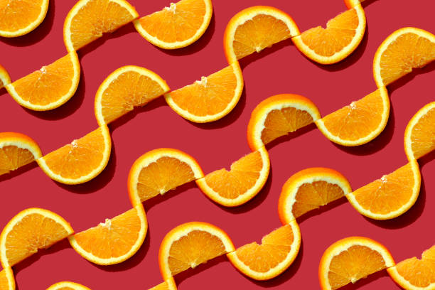 istock Summer composition made from oranges, on dark red  background. Creative Pattern made of slices of orange. Flat lay, top view of colorful fruit pattern of fresh orange slices on orange colorful background. 1370287158