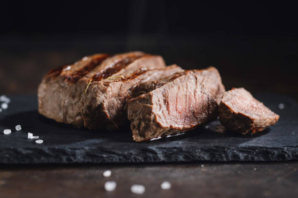 istock Grilled meat cut in slices on dark slate 1370287175