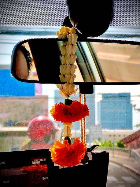 Vertical photo with copy space of a orange marigold garland handing on a blue door in a street market in india