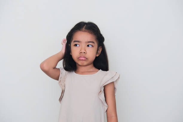 istock Asian kid showing confused expression with her hand scratching head 1370288625