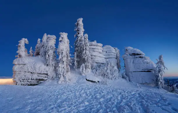 The Dreisesselberg in winter (Czech: Třístoličník), Bavarian Forest, 1,333 metres high. 
Neureichenau / Haidmühle municipality, Freyung-Grafenau district, Lower Bavaria, Bavaria, Germany. Trees and landscape covered by wind, snow and ice, transforms the mountain into a winter dream, winter fairy tale, magic land. The Dreisesselberg in winter (Czech: Třístoličník), Bavarian Forest, 1,333 meters high. German translation: Gemeinde Neureichenau / Haidmühle, Landkreis Freyung-Grafenau, Niederbayern, Bayern, Germany. Trees and landscape covered by wind, snow and ice, transforms the mountain into a winter dream, winter fairy tale, magic land.