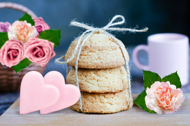 Oatmeal cookies on a wooden board, chocolate hearts and a rose flower. selective focus stock photo
