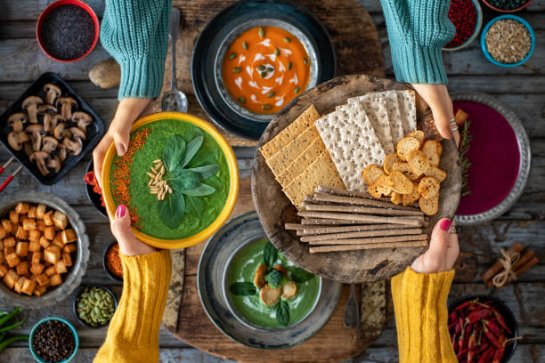 Two women sharing their vegetable soup and grissini breads.
