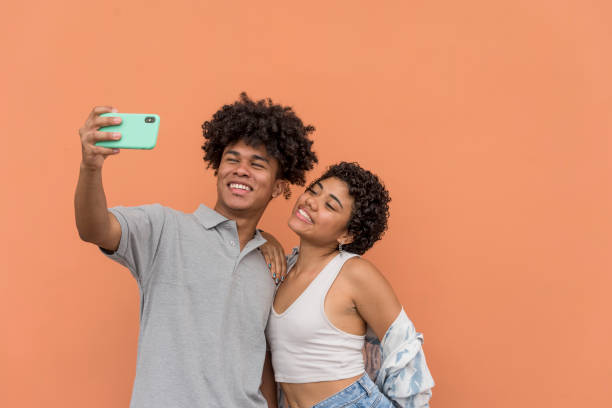 istock African American latin couple using smartphone in neutral background. 1370292823