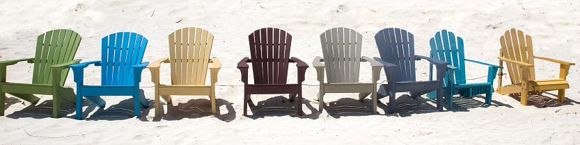 Colorful chairs on sandy beach in Aruba. Banner size