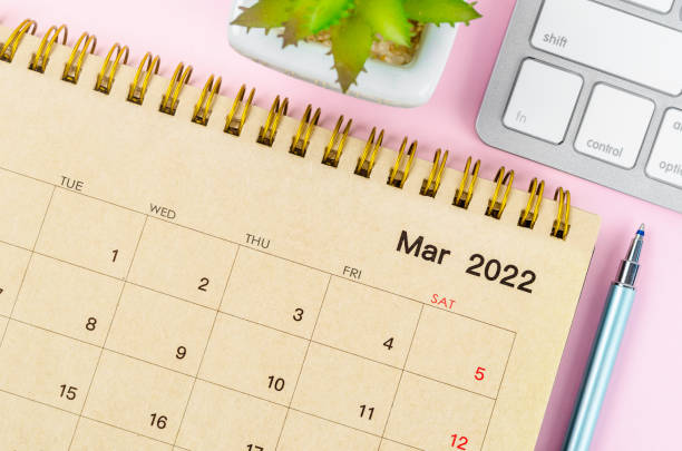 istock March 2022 desk calendar with keyboard computer on pink background. 1370297720