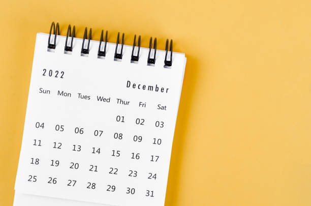 istock December 2022 desk calendar on light yellow background. 1370298604